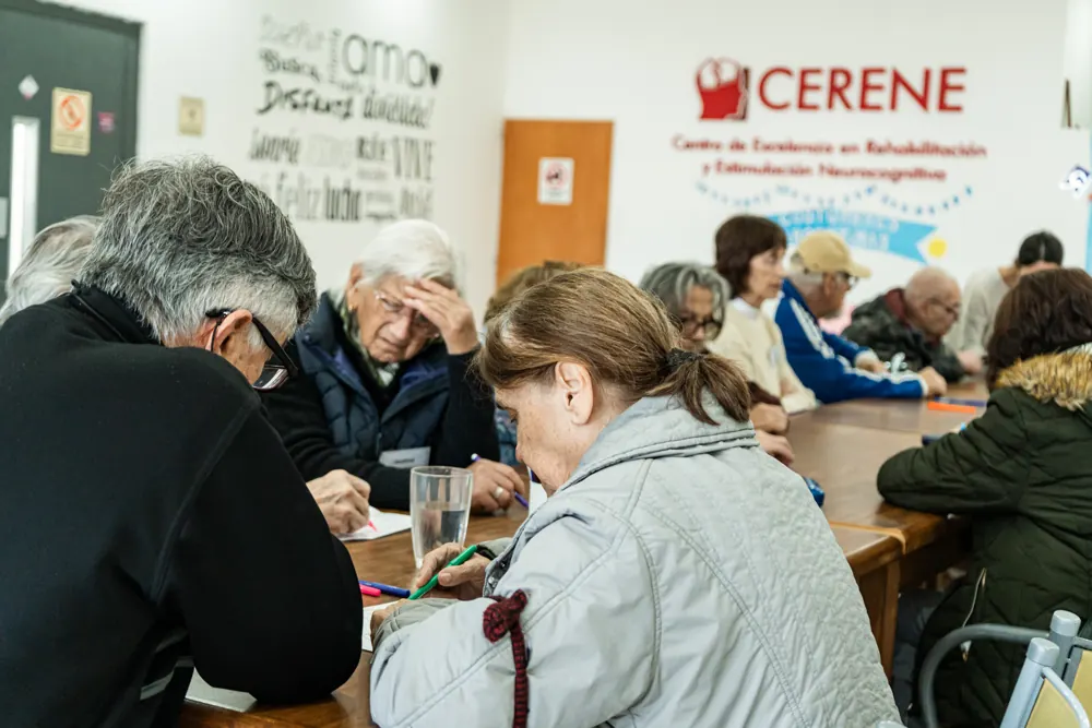 Concurrentes trabajando juntos en una actividad de estimulación cognitiva en la mesa del salón