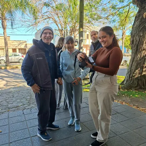 Concurrentes y profesional con una cámara en la vereda